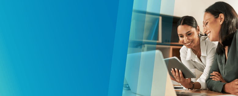 Two smiling businesswomen use Vision33’s Copilot to harness SAP Business One AI on a tablet