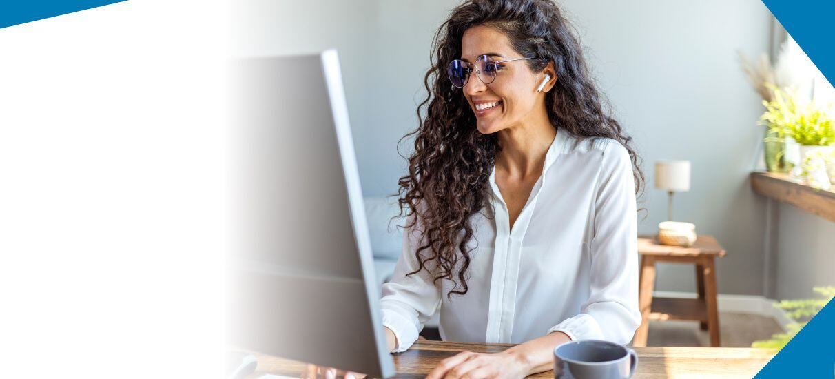 Smiling businesswoman works at a computer in an office