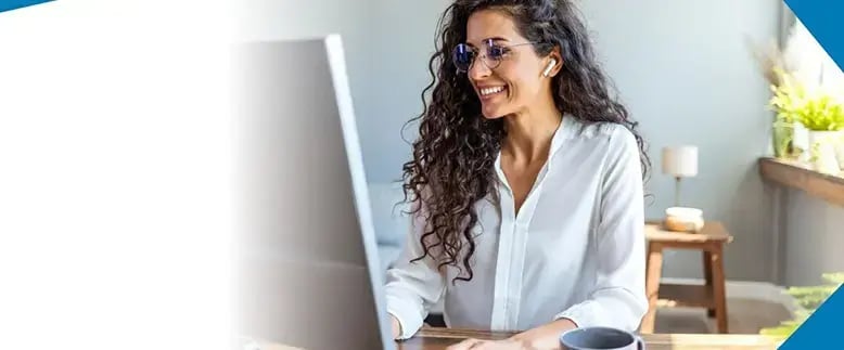 Smiling businesswoman works at a computer in an office